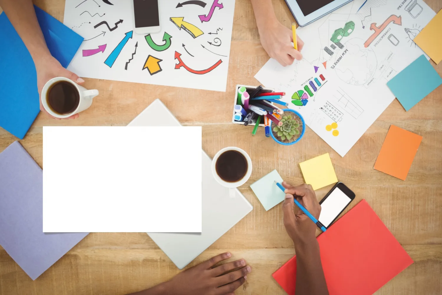 A team planning a digital project with sketches, notes and devices